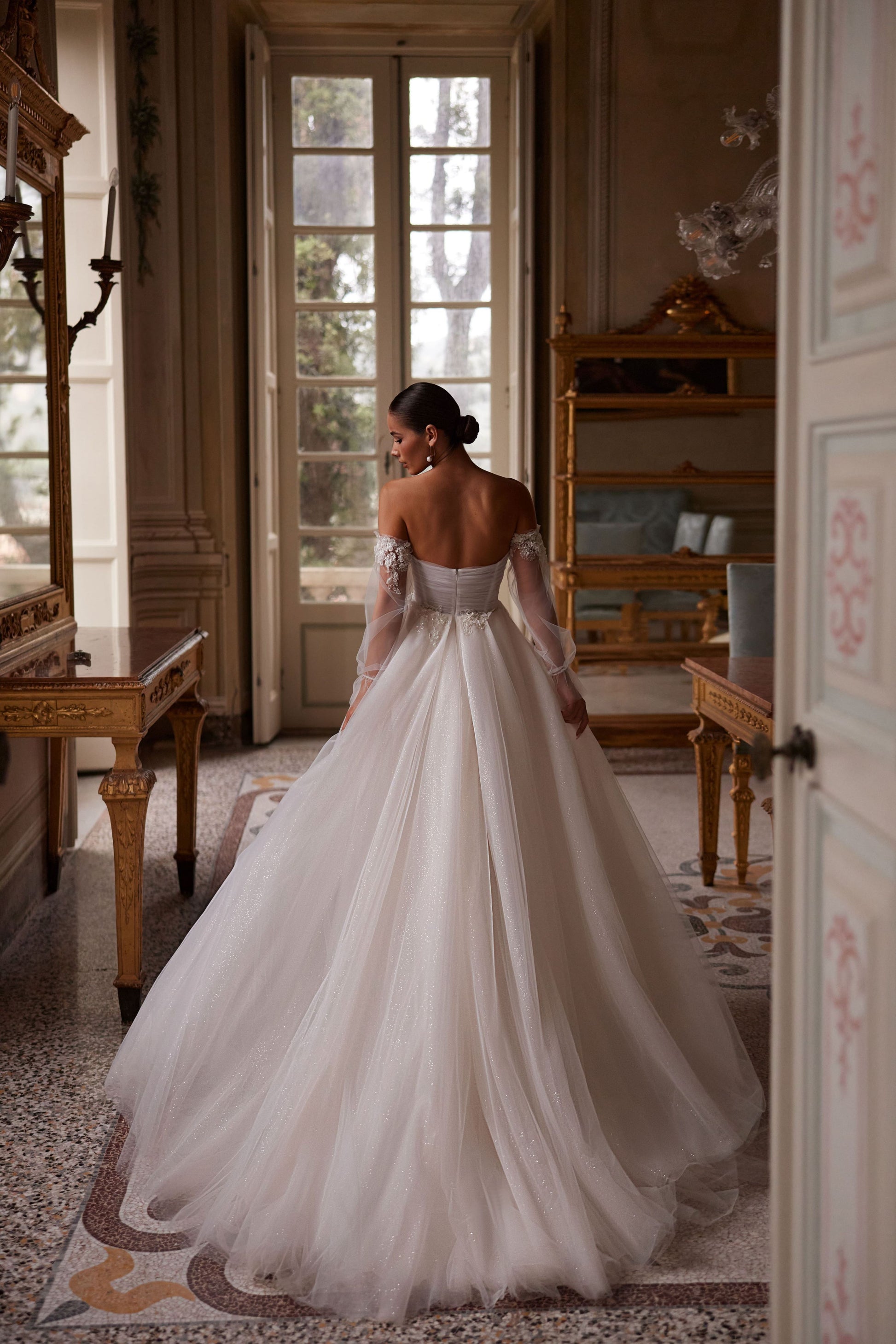 
Expertly crafted, Tiffani is an A-line wedding dress with a sleek high-thigh slit, detachable sleeves, and an illusion sweetheart neckline. Made from luxurious silk tulle and adorned with delicate beading, it exudes timeless elegance for your special day.